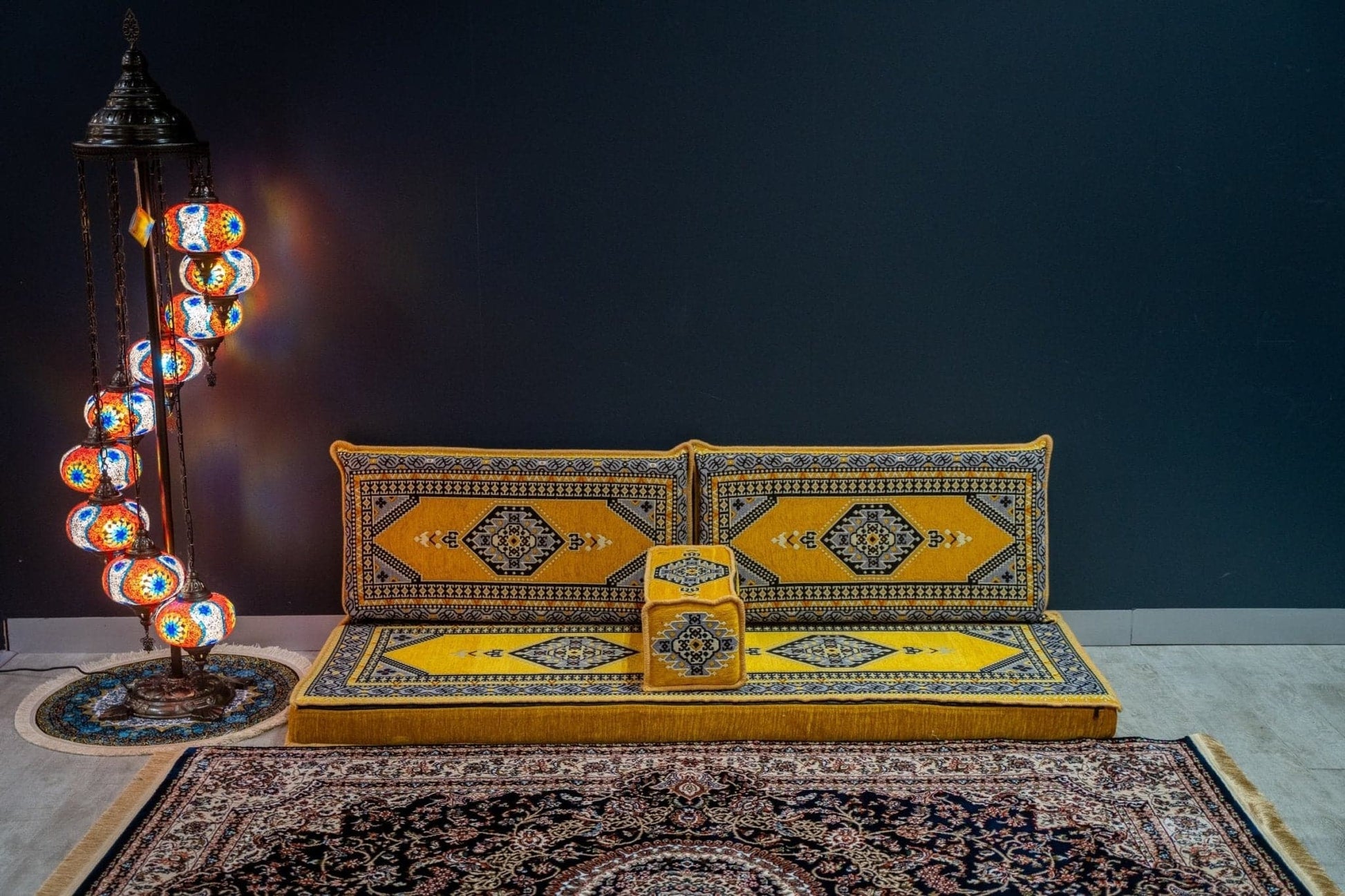 Arabian Majlis Divan Set – Yellow Palace Turkish floor cushions against a dark wall with decorative lantern and rug.