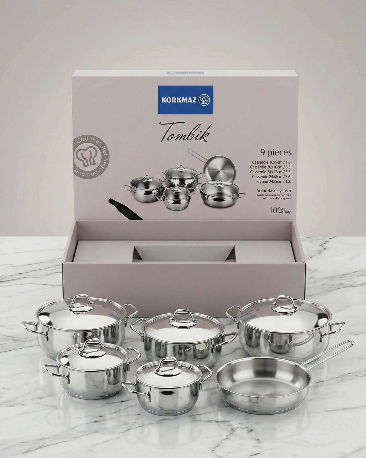 Elevate Your Kitchen with Premium Cookware & Servingware - Korkmaz Tombik 9-piece cookware set displayed on marble.