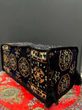 Traditional Turkish Armrest Cushion in navy diamond pattern on a colorful floor rug.