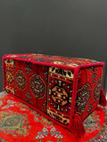 Traditional Turkish Armrest cushion in vibrant red with intricate patterns on a decorative floor covering.