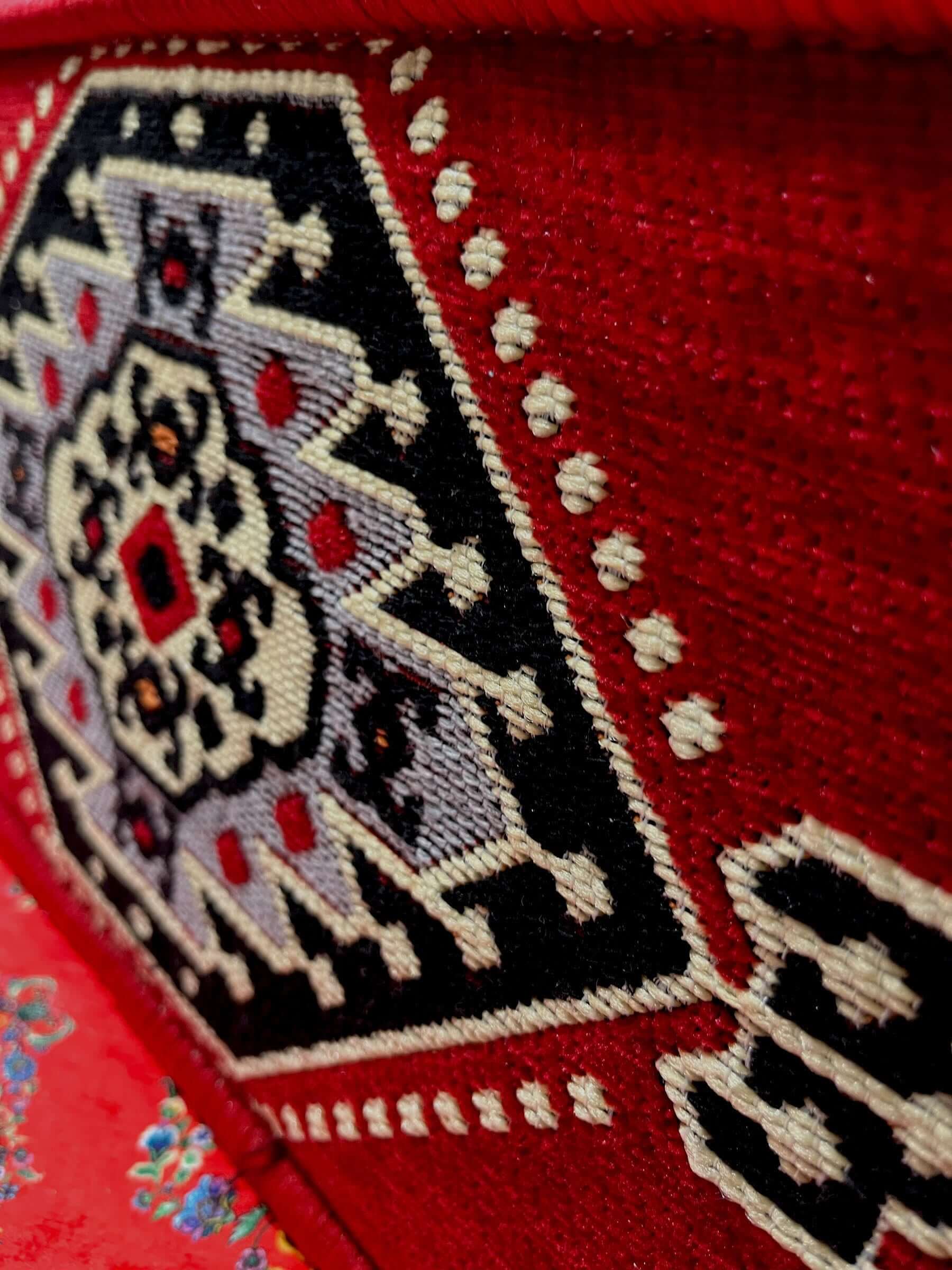 Close-up of Traditional Turkish Armrest cushion showcasing intricate red and black embroidery design.