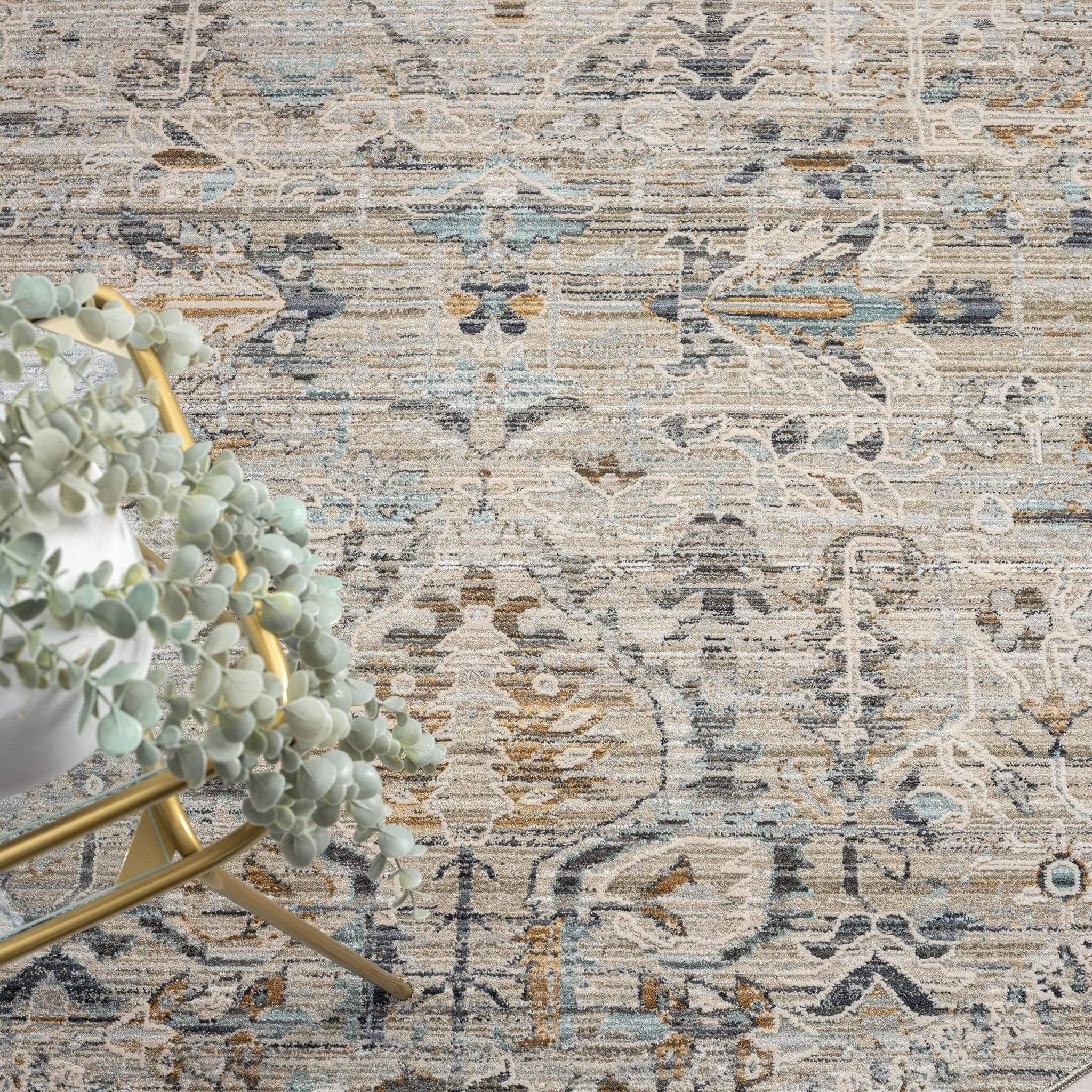 Aubrey 6755 Taupe Round Turkish Rug displaying muted taupe tones and intricate patterns with a potted plant beside it.