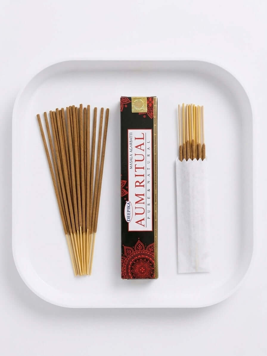 Aum Ritual Incense Sticks displayed in a tray, featuring a pack and individual sticks for calming rituals and meditation.