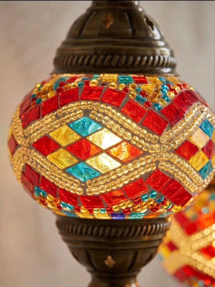 Close-up of a vibrant Turkish mosaic table lamp with red, blue, and yellow diamond patterns.