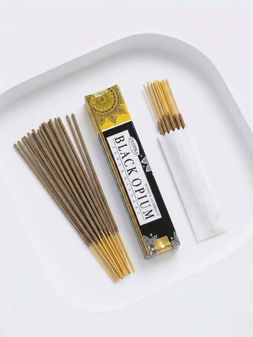 Black Opium Incense Sticks package with incense sticks arranged on a white plate.