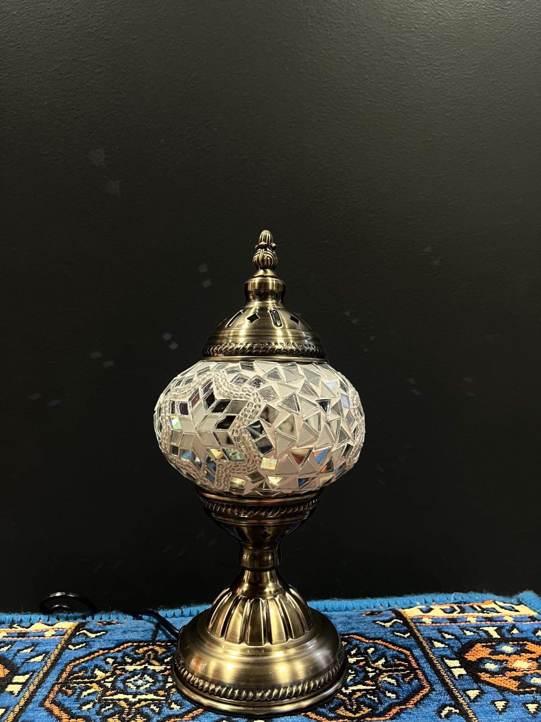 Mosaic Table Lamp showcasing intricate glass design and warm glow on a decorative rug.