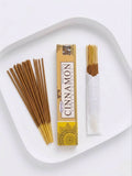 Cinnamon Incense Sticks displayed on a plate with packaging and several incense sticks ready for use.