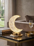 Dimmable crystal crescent moon lamp on a stylish side table, illuminated with elegant ambiance, perfect for bedrooms.