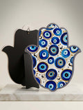 Hamsa Hand wall decor with vibrant blue evil eye motifs, showcasing a unique cultural design.