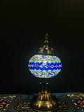 Mosaic Table Lamp featuring a vibrant blue diamond design, casting a warm glow in a stylish setting.