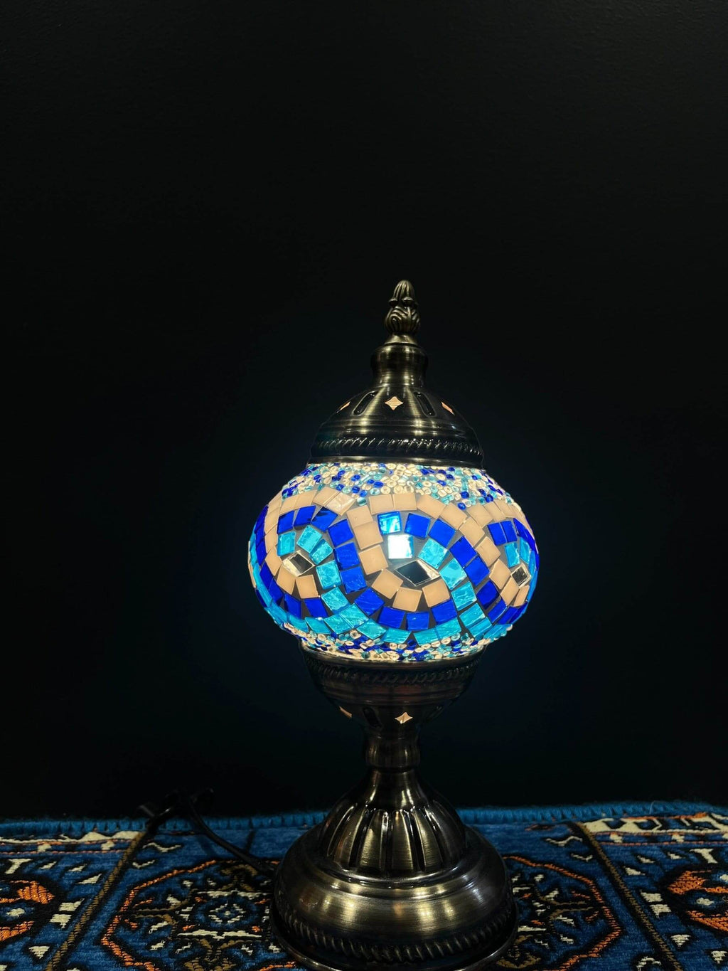 Mosaic Table Lamp glowing with blue and turquoise glass mosaic details on a decorative base.