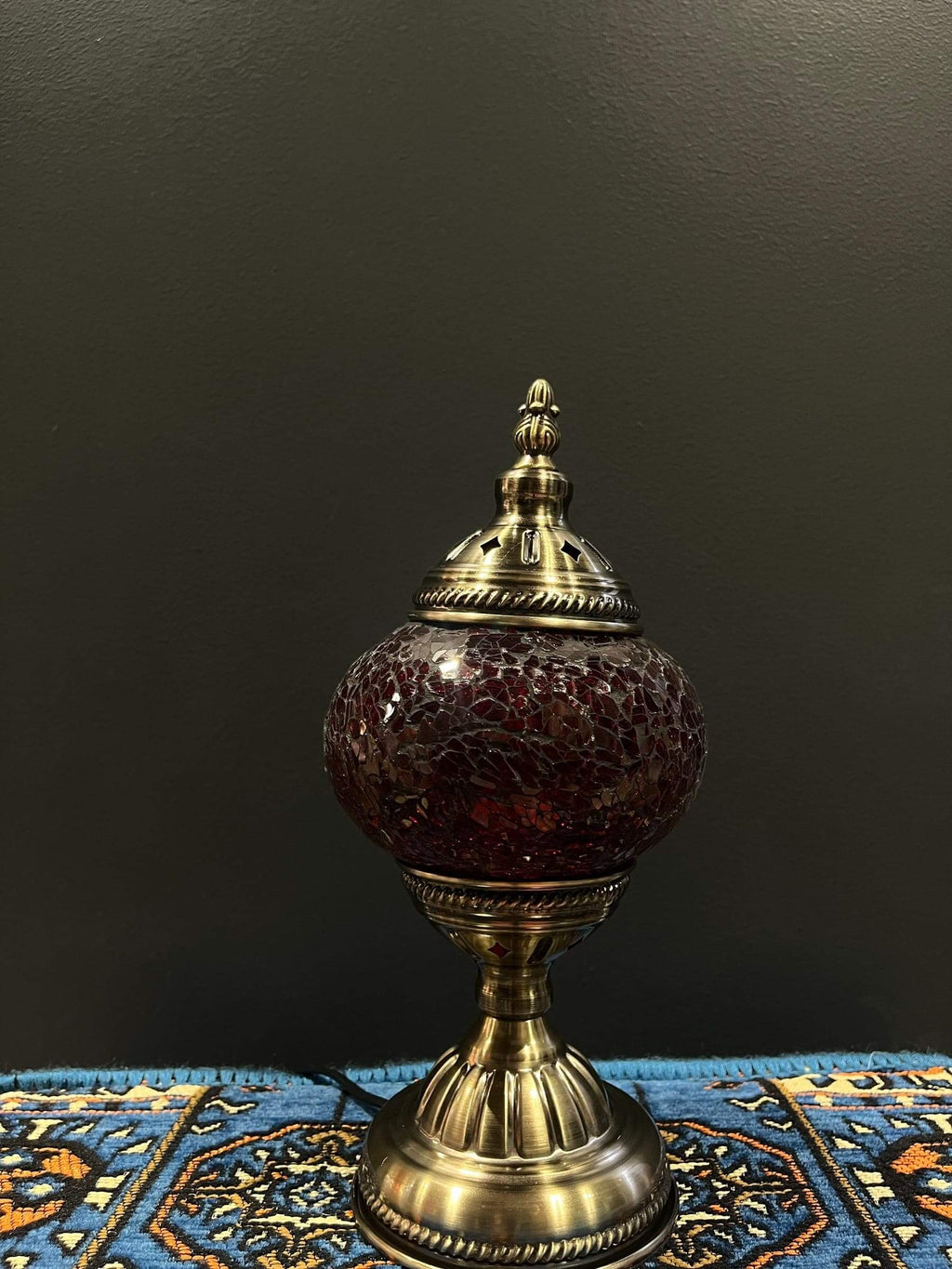 Mosaic Table Lamp with red crackle Turkish glass on a decorative table, providing warm illumination.
