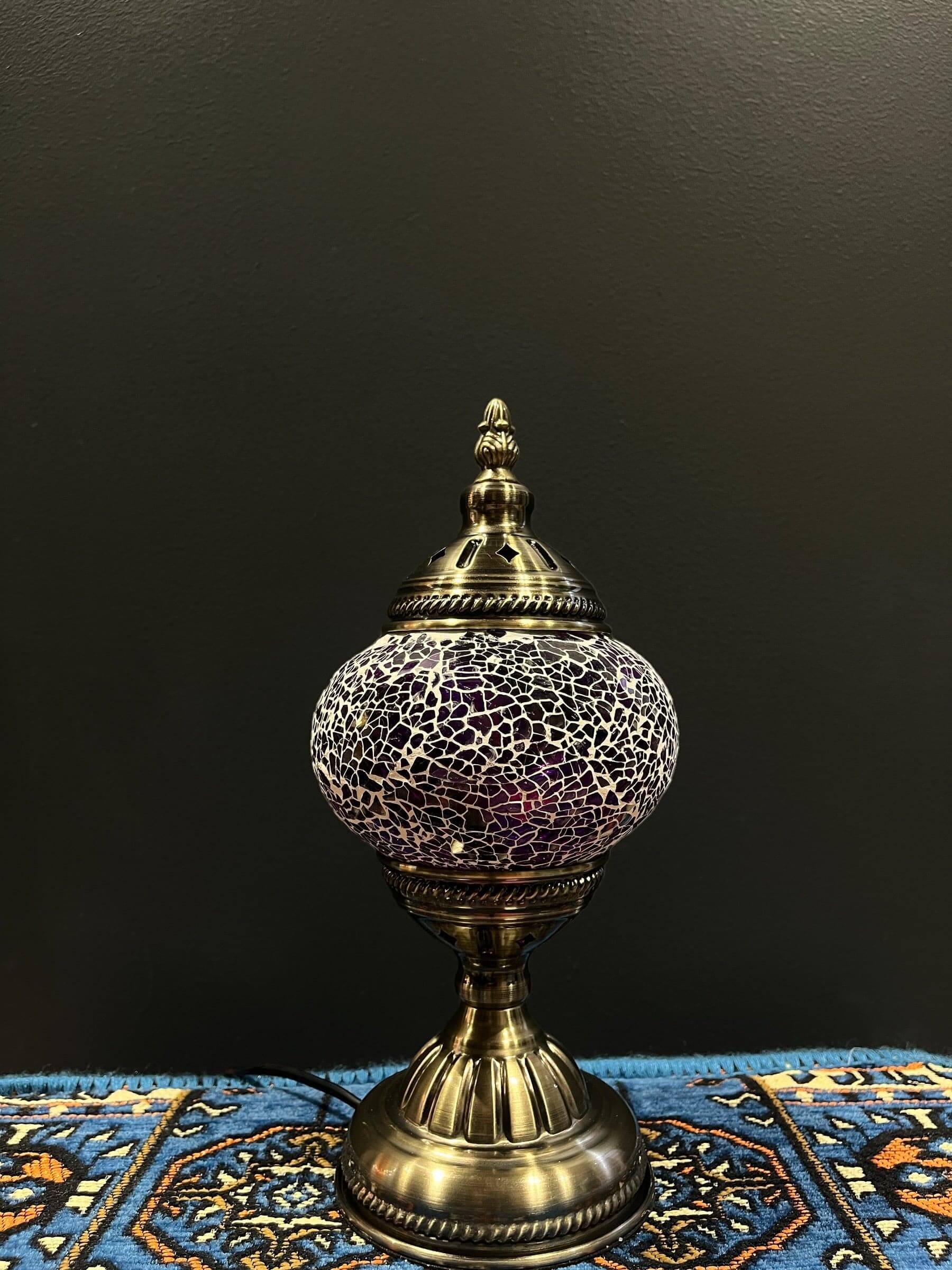 Mosaic Table Lamp showcasing purple crackle design with intricate details and bronze base on decorative fabric.