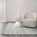 Les Nomades Linear Light Ash Wool Rug styled with furniture
