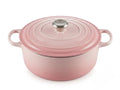 Le Creuset shell pink cast iron pot with a smooth lid and stainless steel knob, showcasing its iconic design.