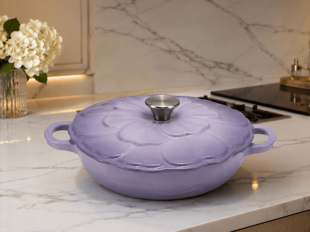 Le Creuset Flower Cast Iron Casserole Dish 26cm in Lavender Purple on a marble countertop.