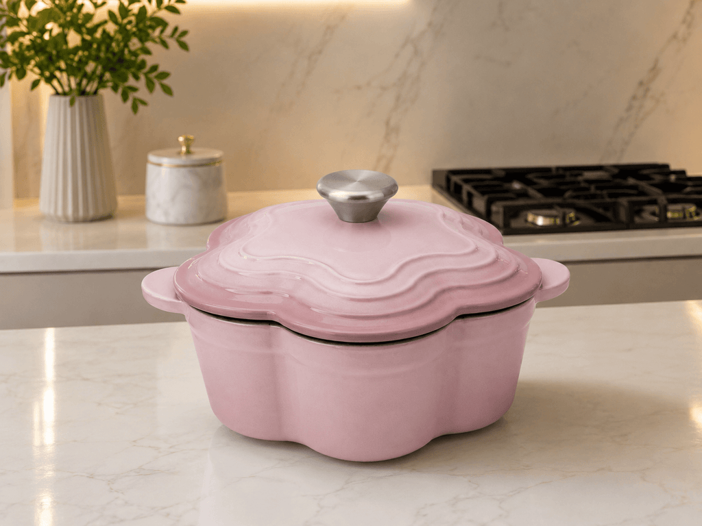 Le Creuset Flower Shaped Cast Iron Cocotte 20cm 2L in Chiffon Pink on a kitchen countertop.