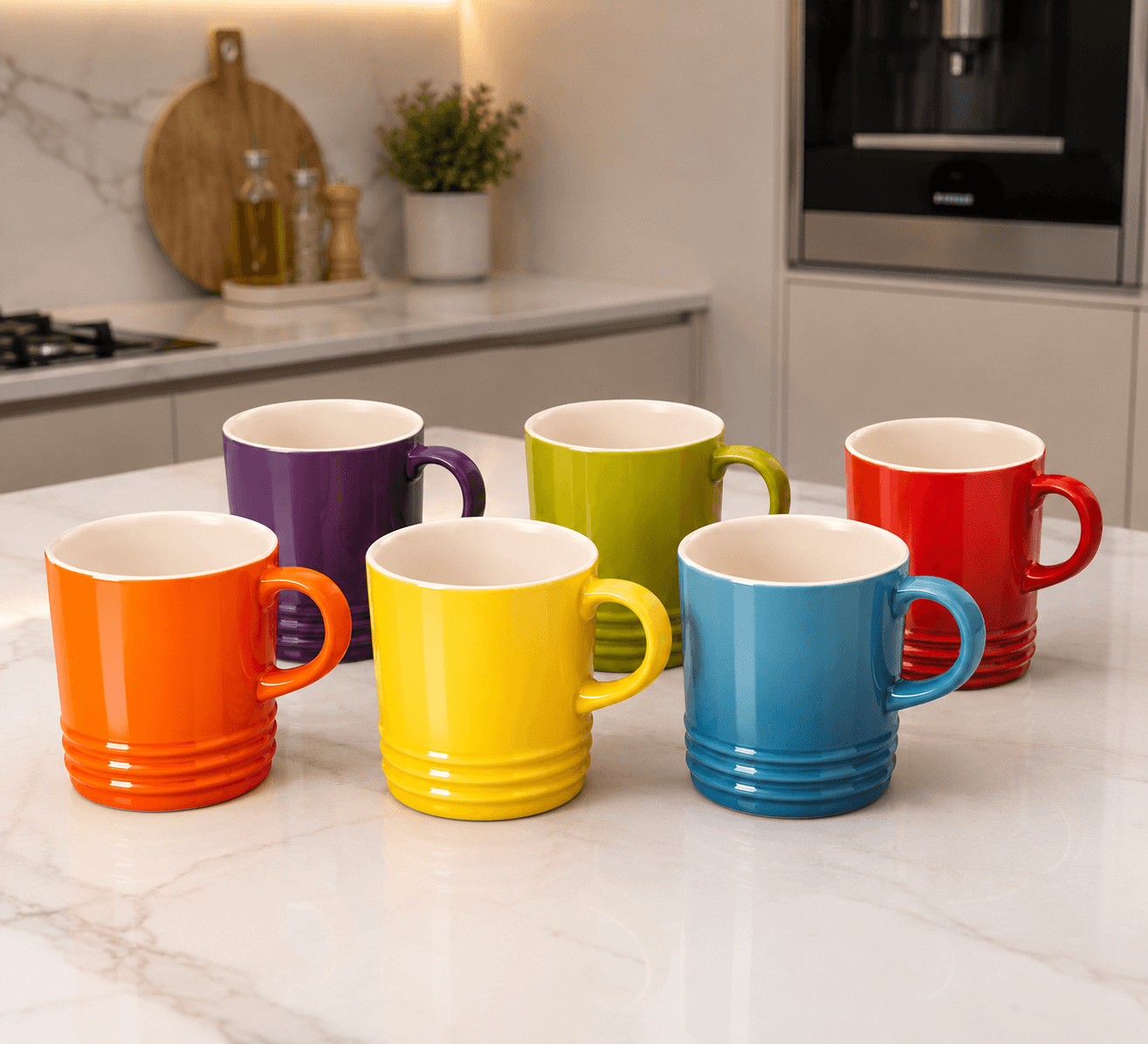 Le Creuset rainbow ceramic mug set displayed on a kitchen countertop with six colorful mugs.