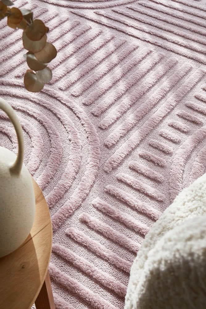 Modern pink textured rug with geometric patterns, adding softness and style to contemporary living spaces.