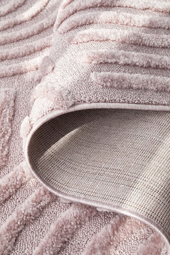 Close-up of the Marigold Dior Pink Modern Textured Rug displaying its soft blush-pink color and geometric pattern. A modern pink textured rug.