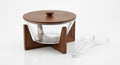 Modern glass salad bowl set with wooden stand and lid, accompanied by serving utensils for elegant dining.