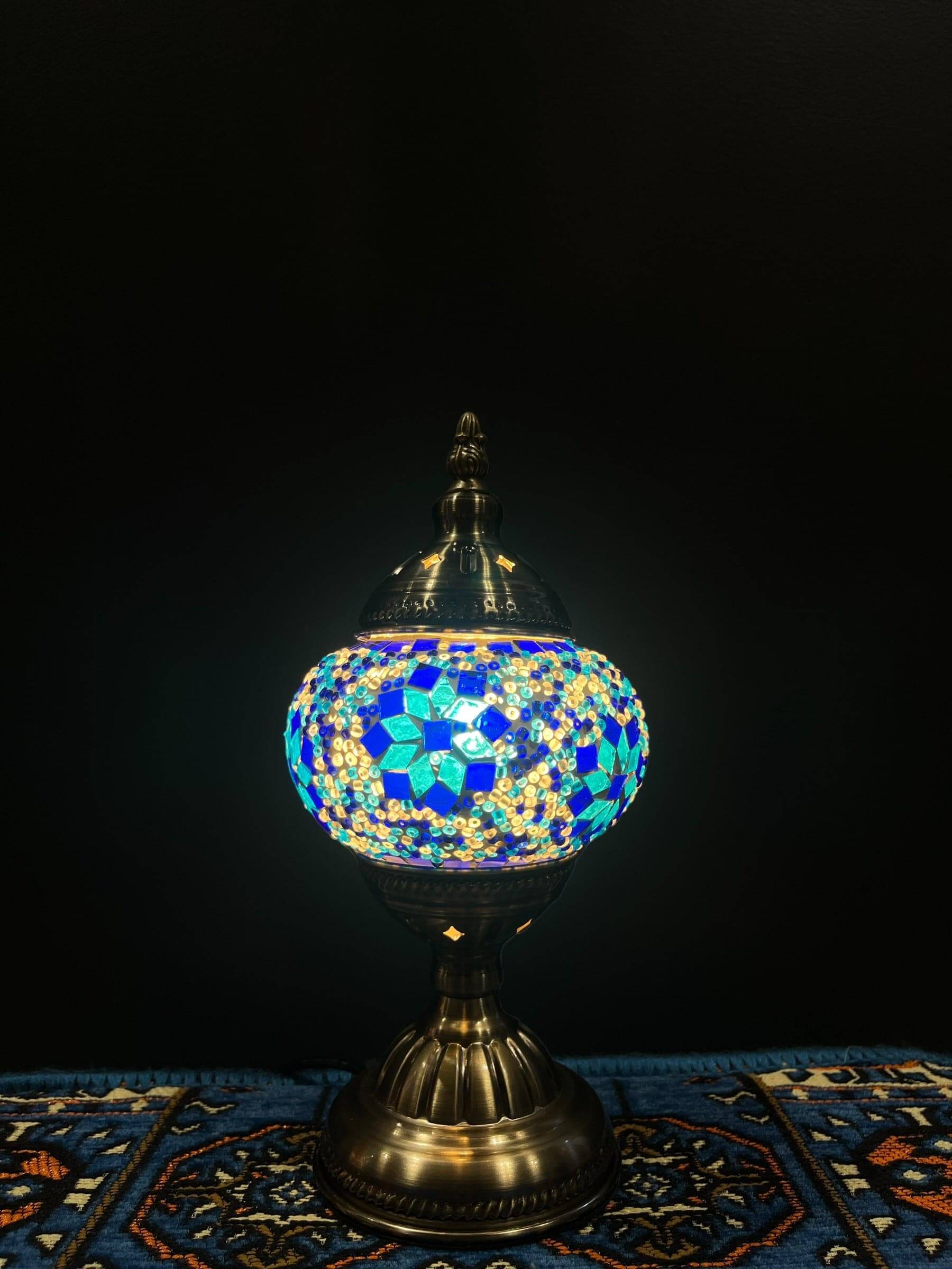 Mosaic Table Lamp with blue flower design illuminating a soft glow, adding charm and elegance to any space.