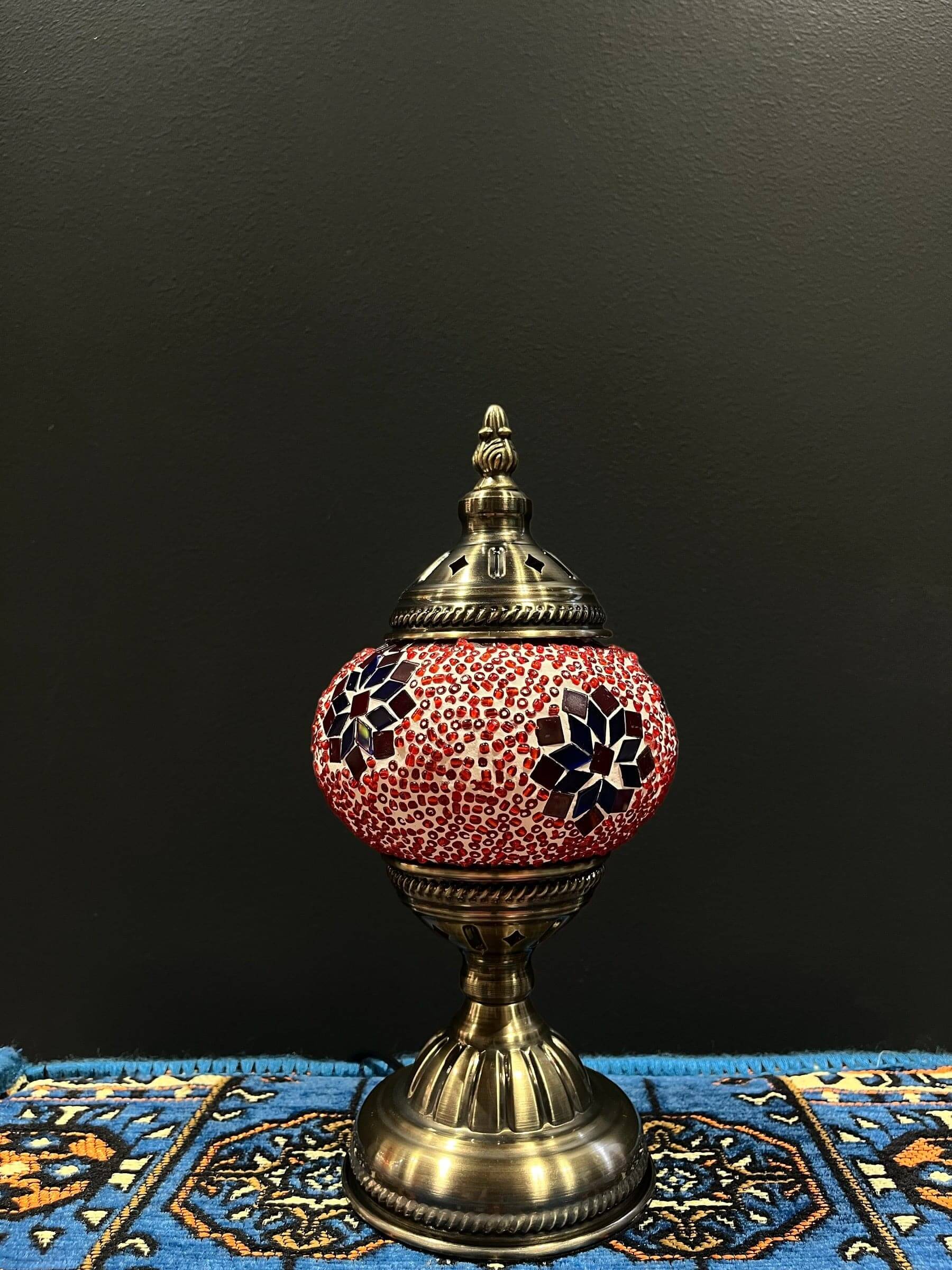 Mosaic Table Lamp with red and blue flower design on glass shade against a dark background.