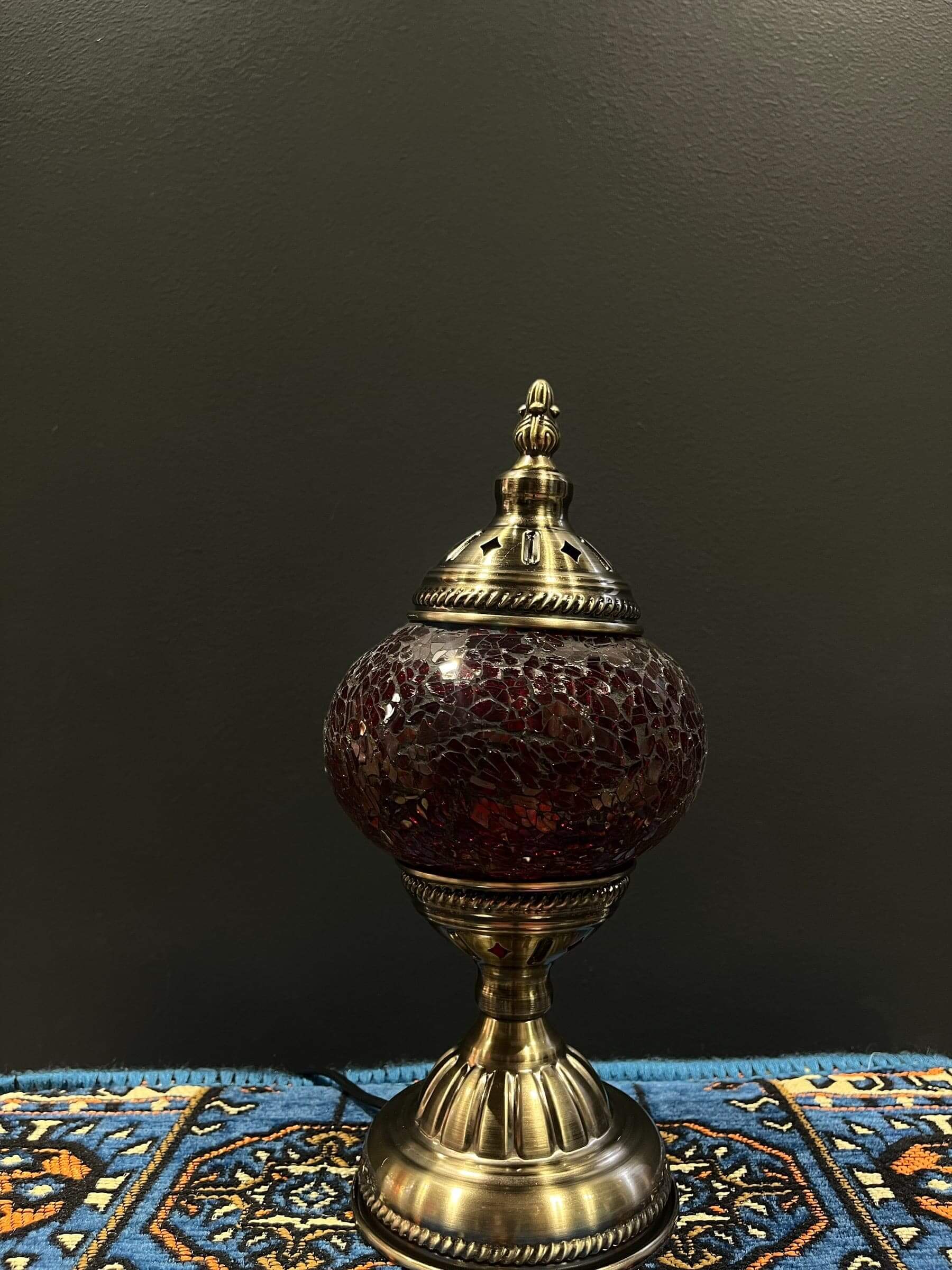 Mosaic Table Lamp with red crackle Turkish glass on a decorative table, providing warm illumination.