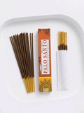 Palo Santo Incense Sticks in box with incense sticks arranged on a plate, showcasing their earthy aroma and calming qualities.