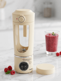 Portable Blender Juicing Cup on a counter with a smoothie and fresh raspberries.
