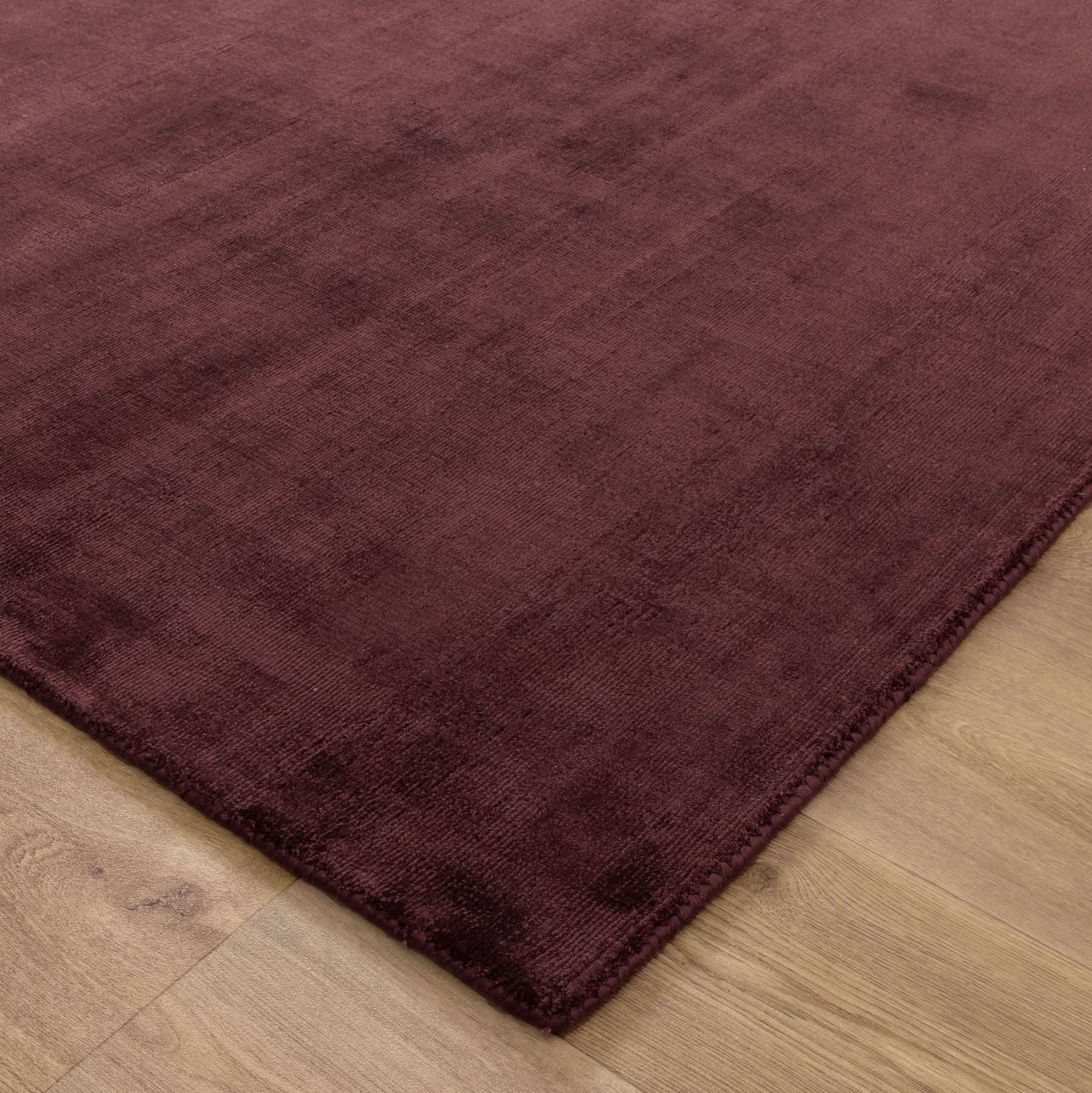 Silken Luxe Chocolate Cherry Rug showcasing a deep chocolate-cherry tone and soft texture on a wooden floor.