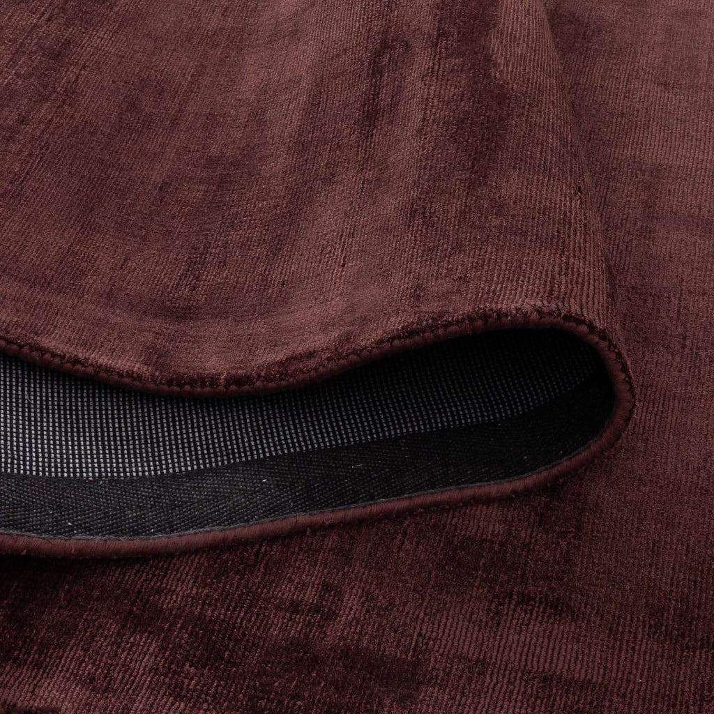 Close-up of the Silken Luxe Chocolate Cherry Rug showcasing its rich deep chocolate color and soft luxurious texture.