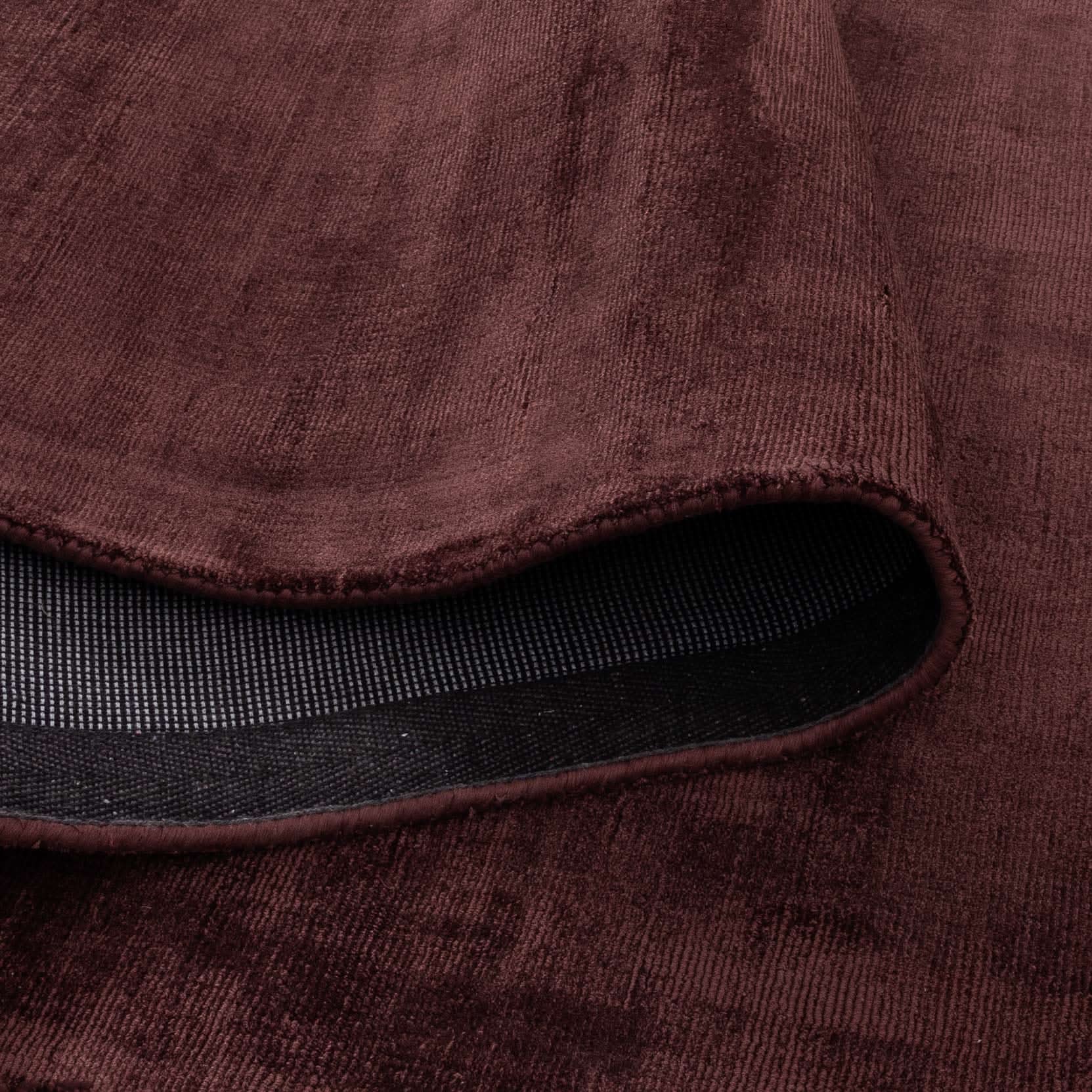 Close-up of the Silken Luxe Chocolate Cherry Rug showcasing its rich deep chocolate color and soft luxurious texture.