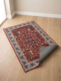 Traditional Red Prayer Mat with blue border, featuring intricate geometric and floral patterns on wooden floor.