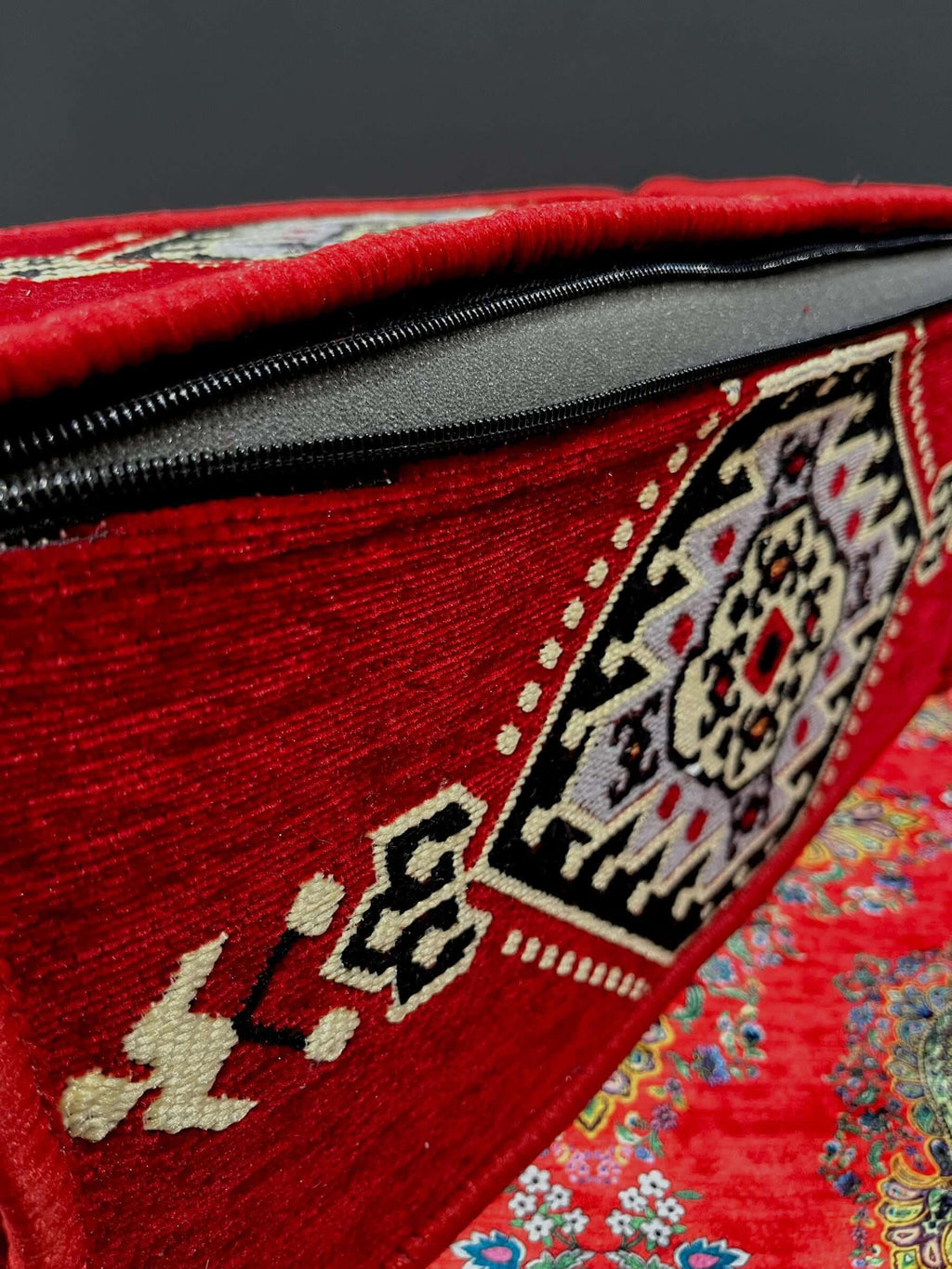 Traditional Turkish Armrest cushion with vibrant patterns and zipper detail on a rich red background.