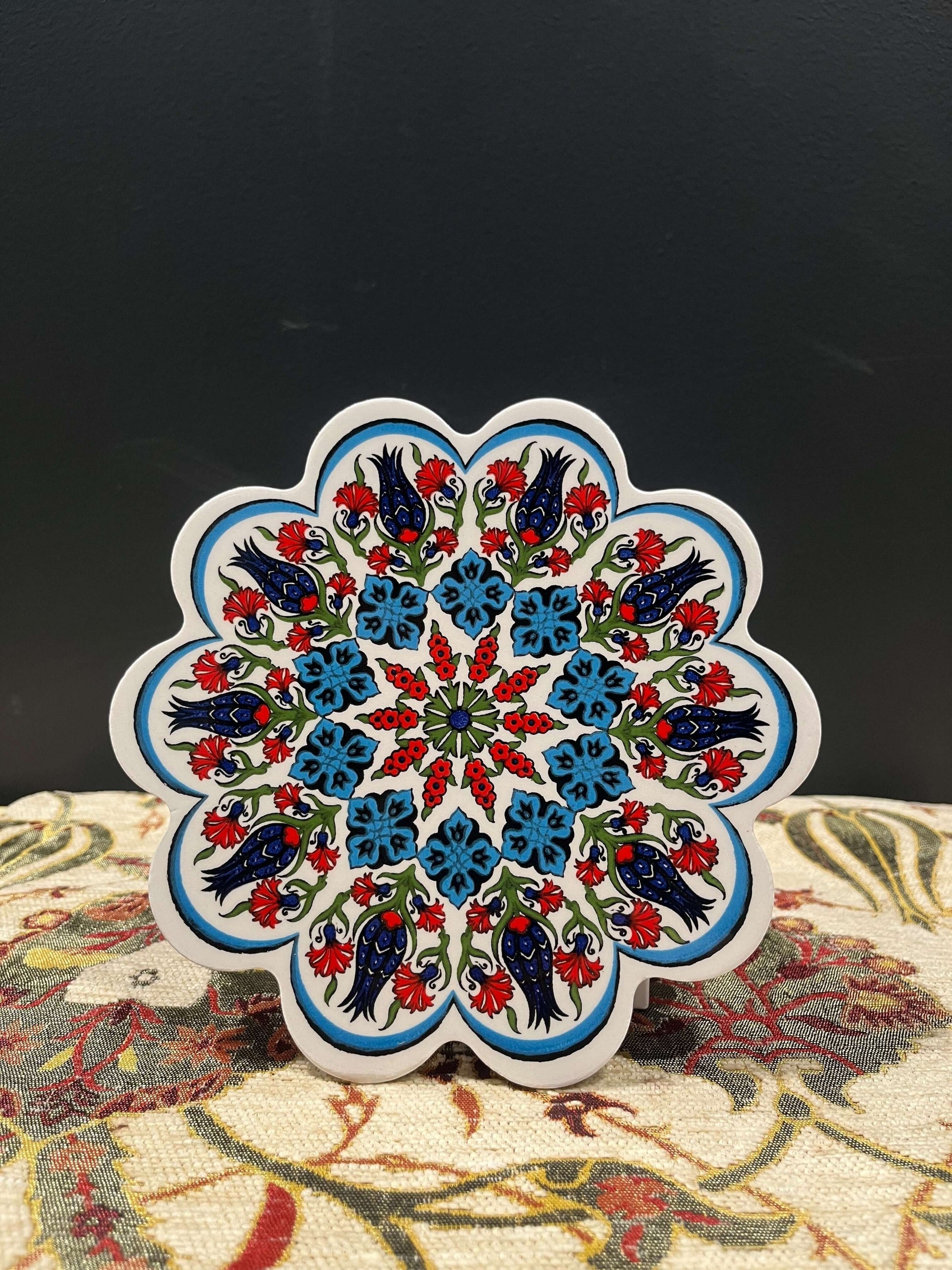 Turkish Ceramic Trivet Blue-White-Red-Discover our Turkish Ceramic Trivet, a perfect blend of artistry and functionality. Crafted in Turkey, this 18cm heat-resistant trivet protects surfaces and features a vibrant mosaic design inspired by Turkish art. Ea