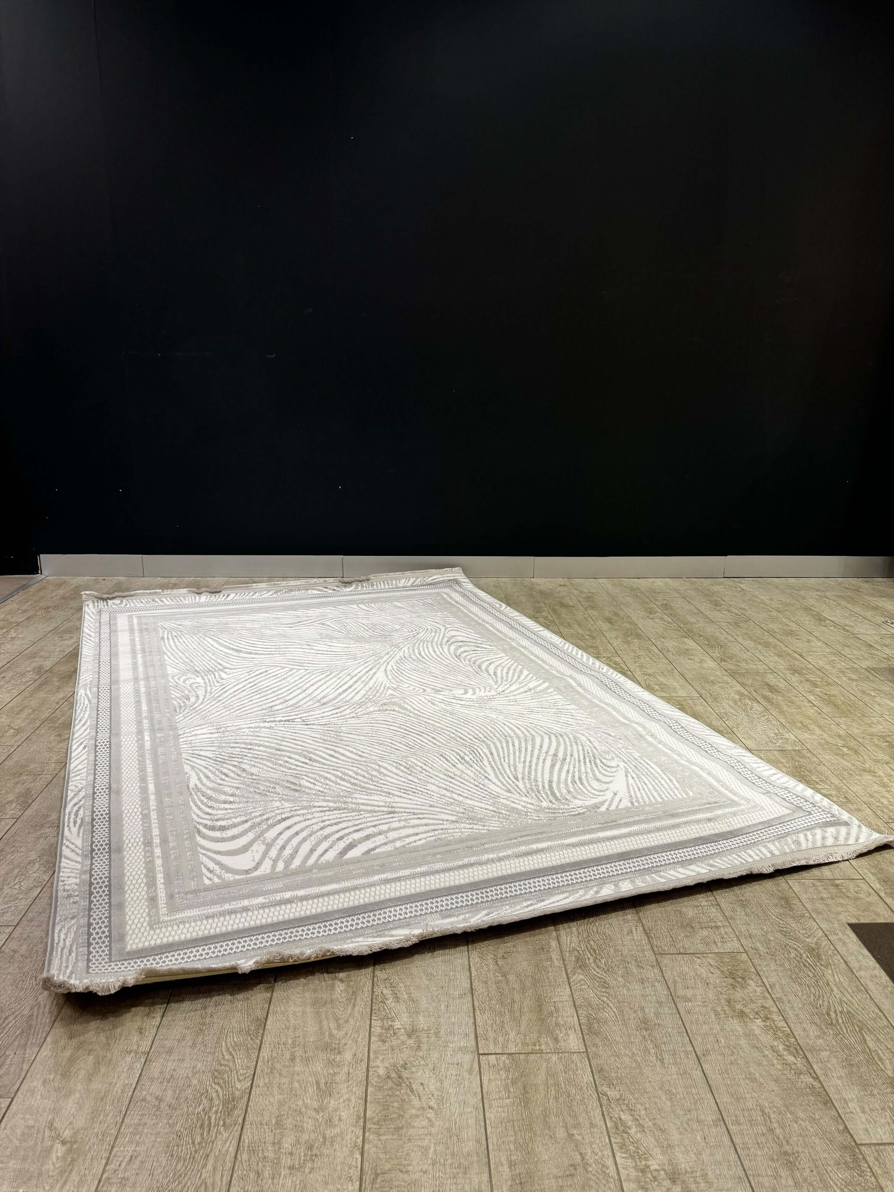 Classic Medallion Turkish Rug on wooden floor against a dark wall, showcasing its textured luxe design.