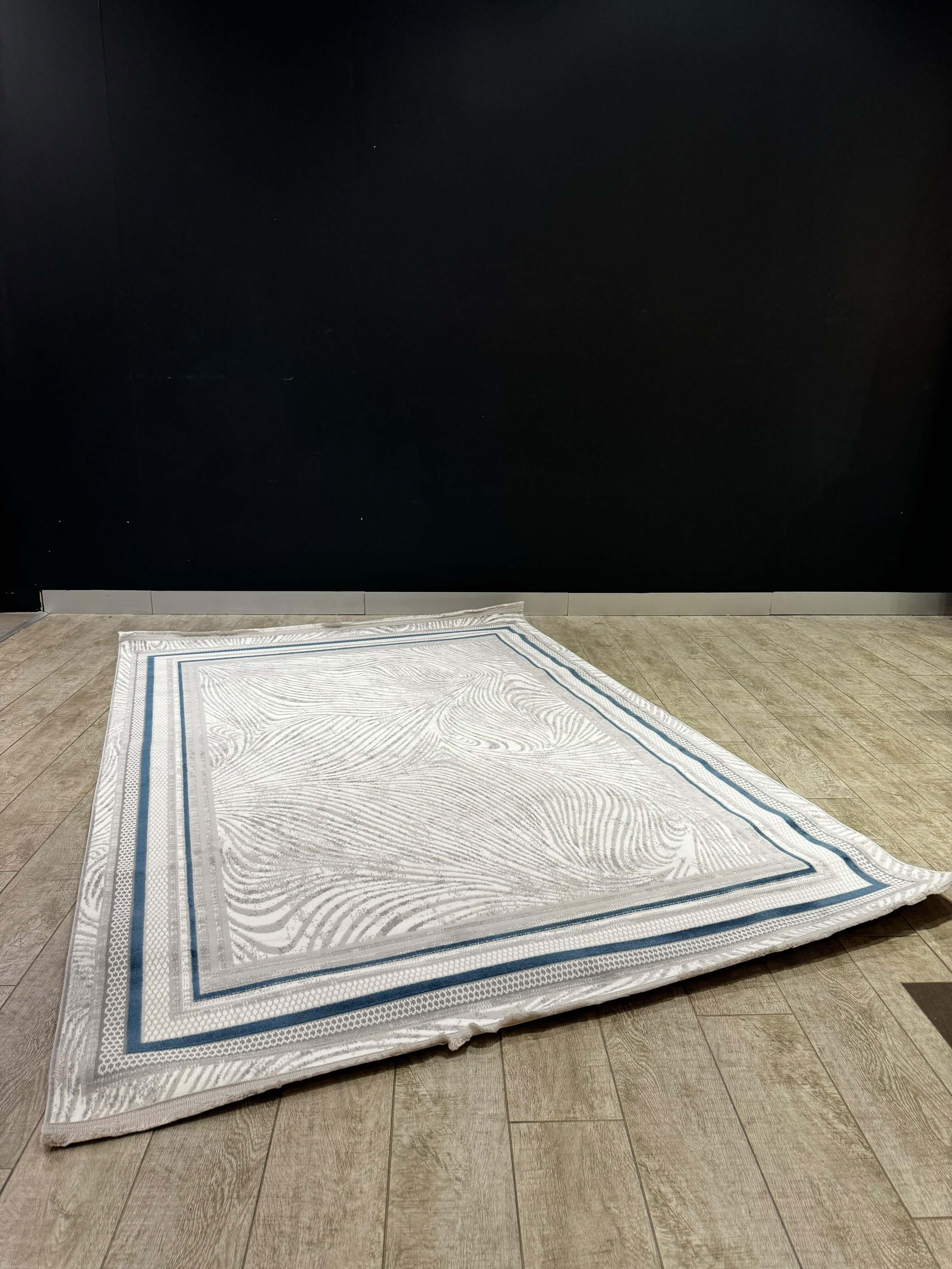 Classic Medallion Turkish Rug on wooden flooring with textured design and blue border.