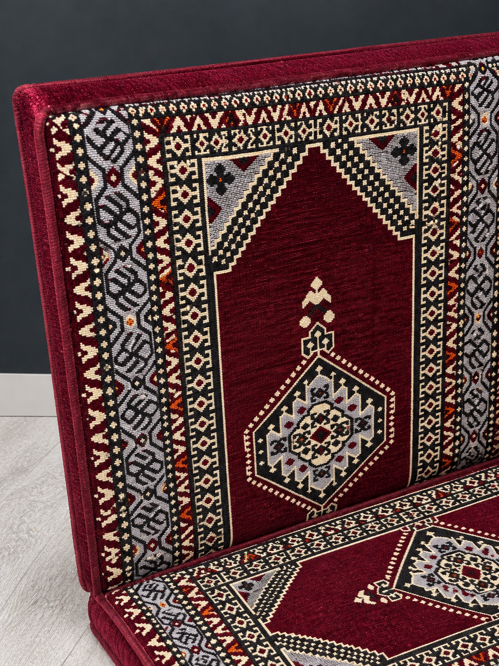 Close-up of the Maroon Palace sofa's burgundy fabric and geometric pattern