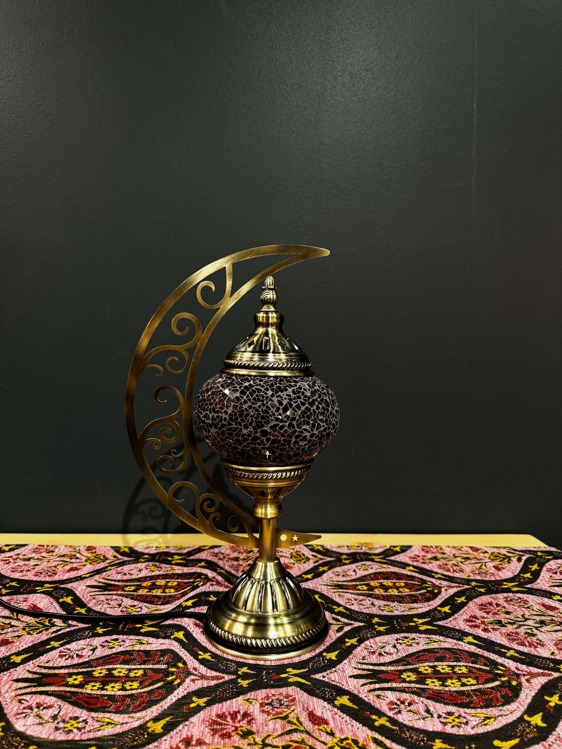 Amber Twilight Turkish Mosaic Table Lamp with crescent moon design and intricate scrollwork, creating a warm ambiance.