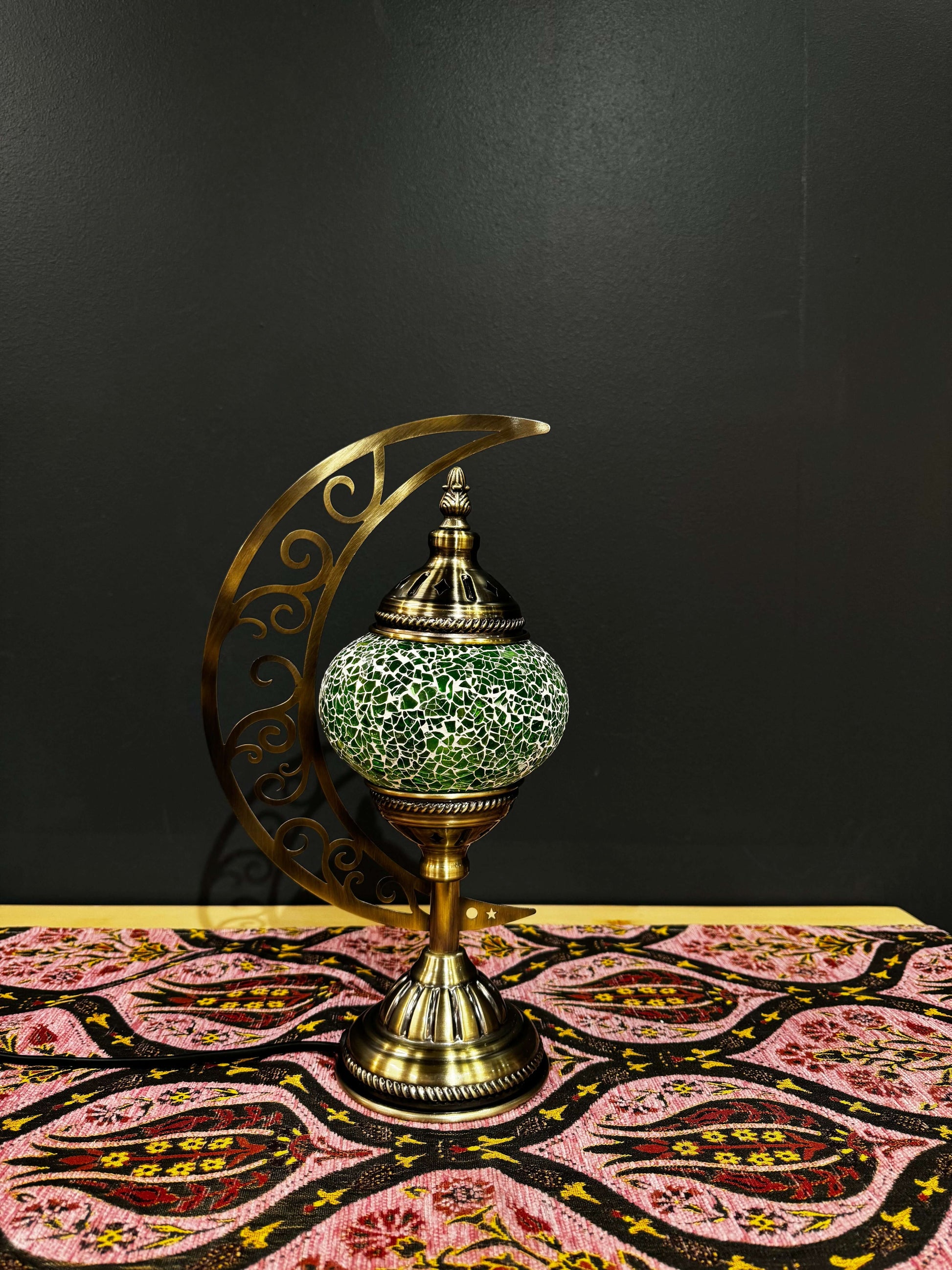 Lime Glow Turkish mosaic table lamp with crescent moon stand in vibrant green, illuminating a stylish decor setting.