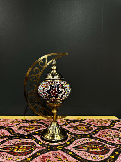 Radiant Starburst Turkish Mosaic Lamp in crescent moon design with vibrant colors on decorative table.