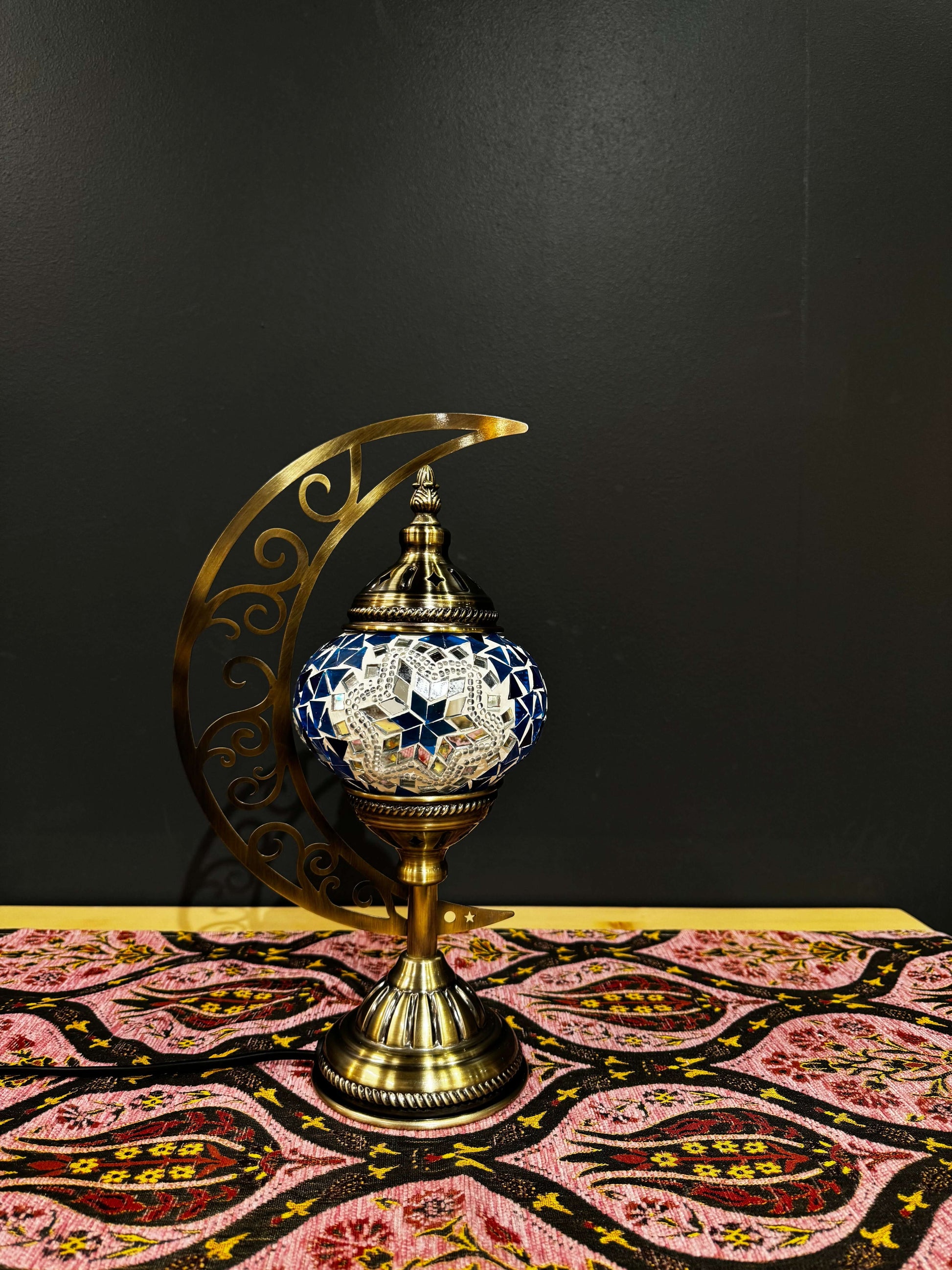 Azure Star Turkish Mosaic Lamp with crescent moon stand and vibrant star Mosaic Table Lamp design on decorative fabric.