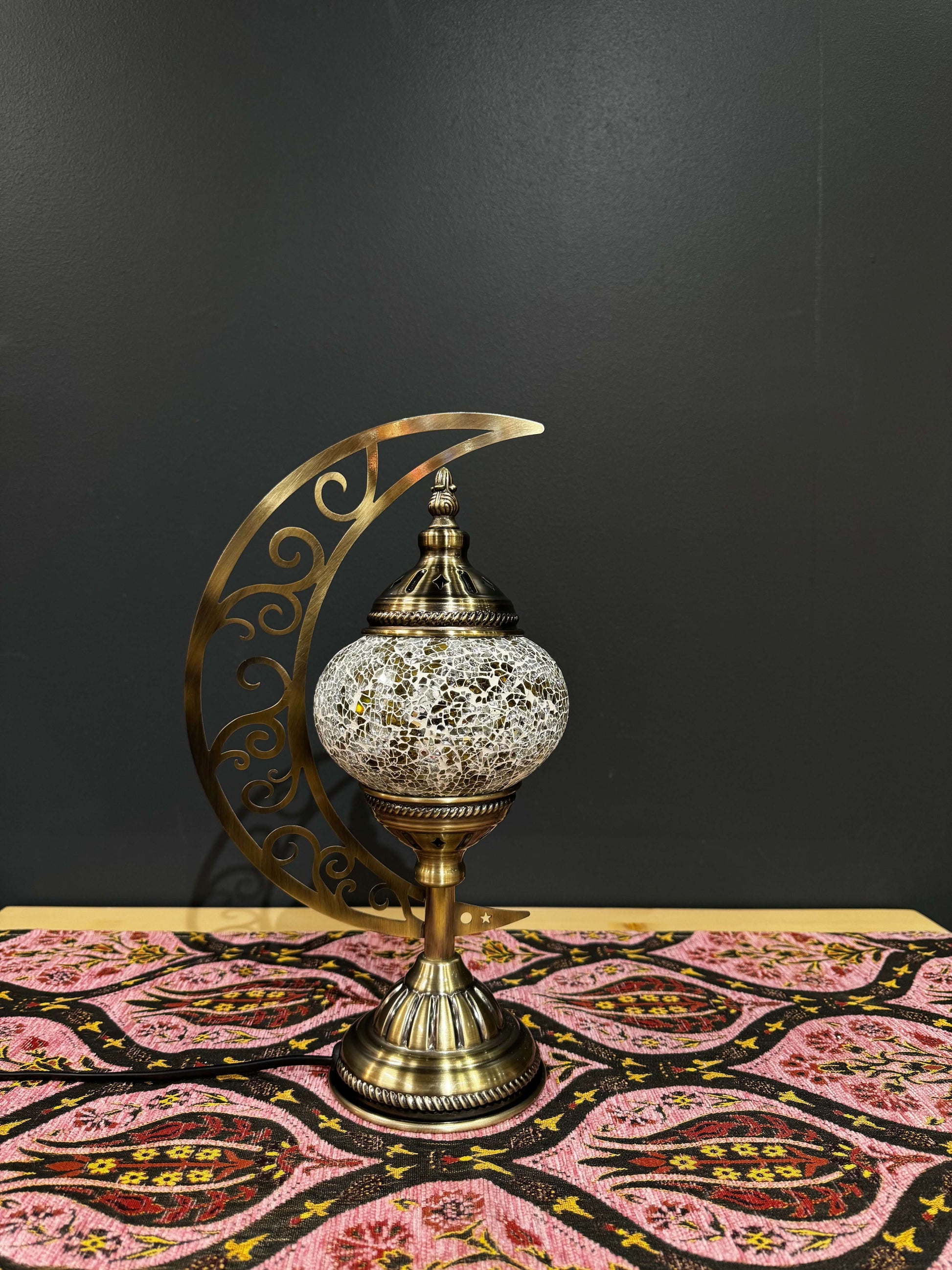 Golden Twilight Turkish Mosaic Lamp with crescent moon stand on a decorative table, showcasing intricate design and warm glow.