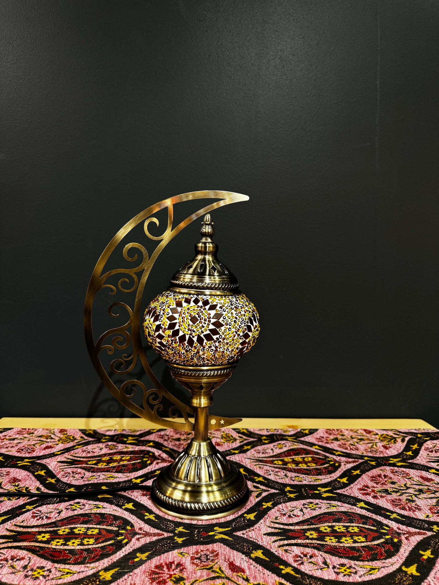 Amber Glow Turkish Mosaic Lamp with crescent moon stand on decorative table, featuring vibrant amber mosaic design.