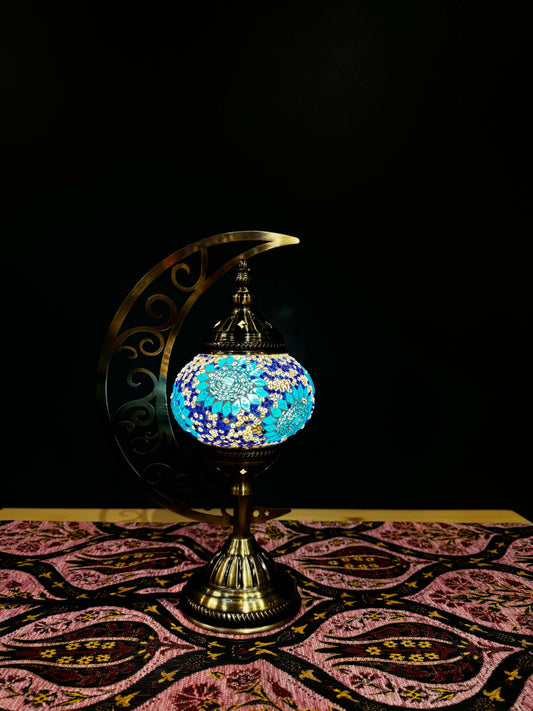 Turquoise Dream Turkish mosaic lamp on a crescent moon stand, showcasing vibrant blue and gold floral patterns.