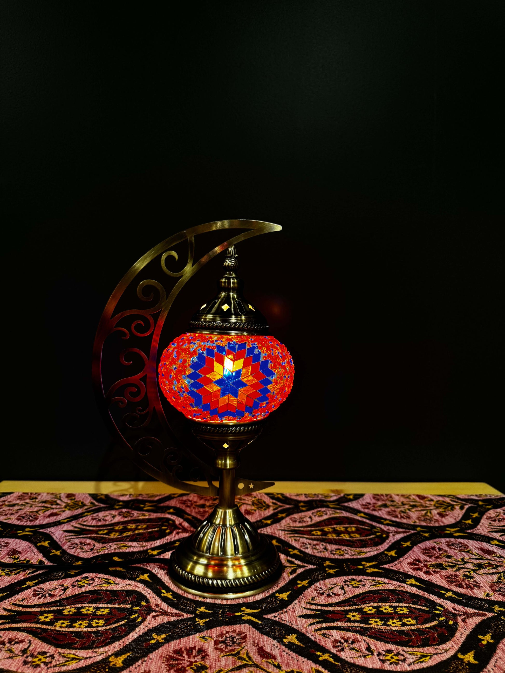 Crimson Star Turkish Mosaic Lamp with crescent moon stand, featuring vibrant red and blue mosaic patterns on a table.