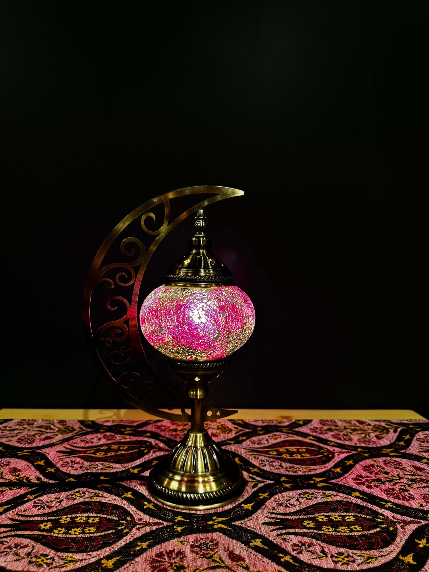 Rose Radiance Turkish Mosaic Lamp with crescent moon stand, vibrant rose and purple mosaic design, soft glow, on decorative table.