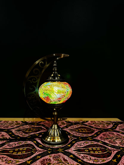 Spring Glow Turkish Mosaic Lamp in vibrant colors on ornate table, showcasing crescent moon design and intricate glass work.